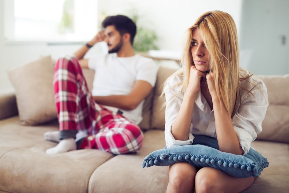 Unhappy couple sitting on a sofa