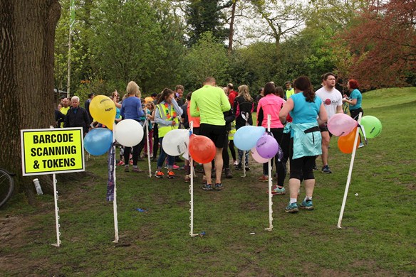 Balloons in front of people scanning barcode and getting tokens